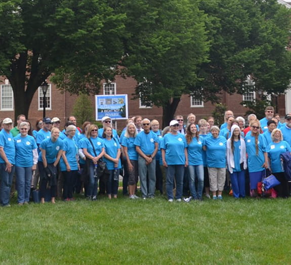 Group of volunteers standing together in a grassy field.