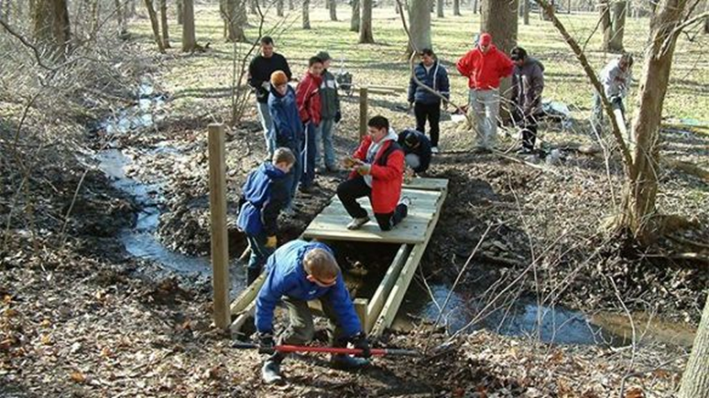 Group of people working near water during a conservation project.