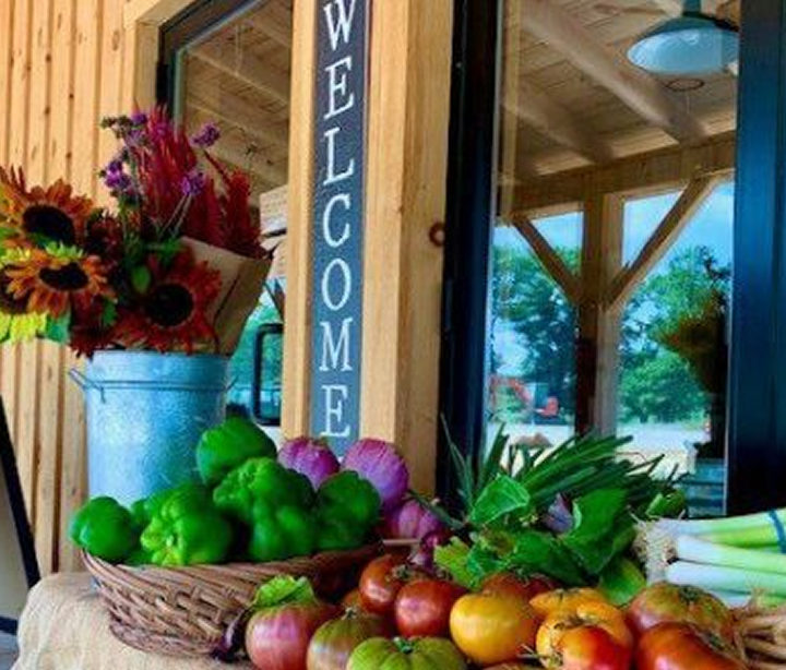 Flowers and gifts displayed near a welcome sign.